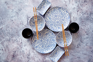 Image showing Empty oriental style dishware set on gray stone background