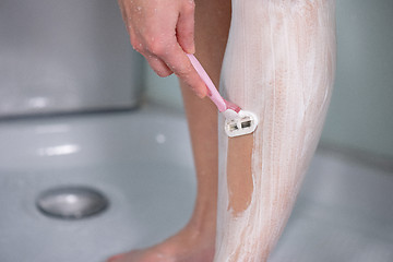 Image showing Woman shaving legs at bathroom