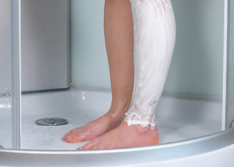 Image showing Woman shaving legs at bathroom