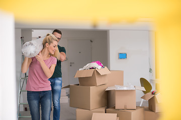 Image showing couple carrying a carpet moving in to new home