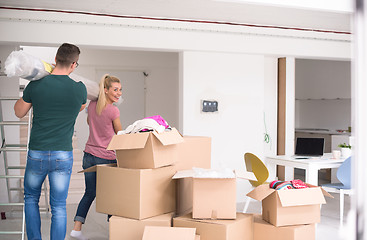 Image showing couple carrying a carpet moving in to new home