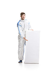 Image showing Young male decorator painting with a poster climbed a ladder isolated on white background.