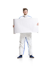 Image showing Young male decorator painting with a poster climbed a ladder isolated on white background.