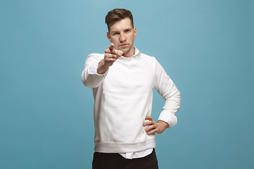 Image showing The overbearing businessman point you and want you, half length closeup portrait on blue background.