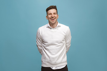 Image showing The happy business man standing and smiling against blue background.