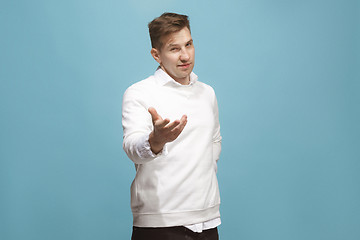 Image showing The happy businessman standing and smiling against blue background.