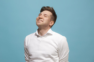 Image showing The happy business man standing and smiling against blue background.