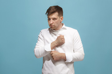 Image showing The young emotional angry man screaming on blue studio background