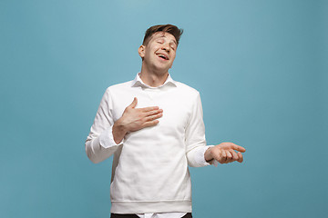 Image showing The happy businessman standing and smiling against blue background.