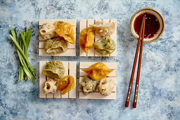 Image showing Delicious mixed kinds of chinese dumplings served on wooden stands