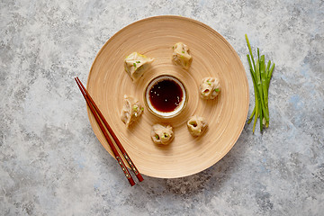 Image showing Delicious chinese dumplings served on wooden plate