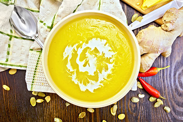 Image showing Soup-puree pumpkin with cream in bowl on board top