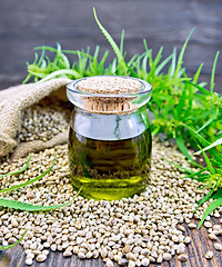 Image showing Oil hemp in jar with seed on wooden board