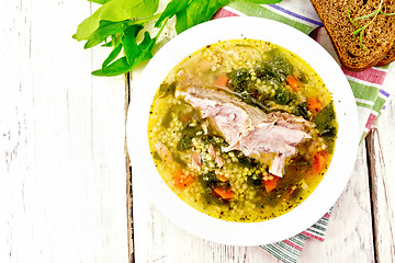 Image showing Soup with couscous and spinach in plate on light board top