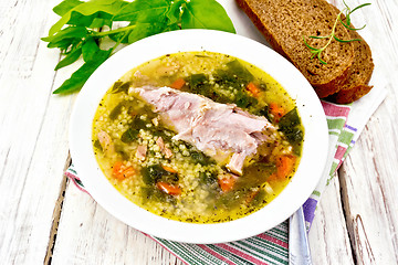 Image showing Soup with couscous and spinach in plate on light board