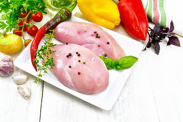 Image showing Chicken breast raw in plate with vegetables and spices on board