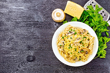 Image showing Fusilli with mushrooms in plate on board top