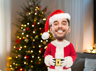 Image showing smiling man in santa clothes over christmas tree