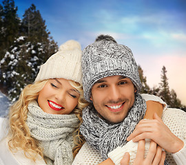 Image showing smiling couple in sweaters over winter background