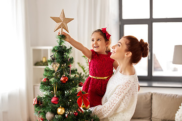 Image showing mother and daughter decorating christmas tree