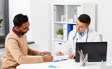 Image showing doctor with laptop and male patient at hospital