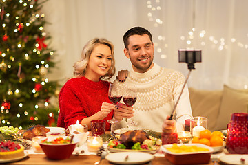 Image showing couple taking picture by selfie stick at christmas