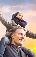 Image showing happy father carrying son over sky background