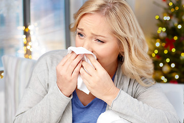 Image showing close up of ill woman blowing nose on christmas