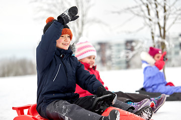 Image showing happy kids sliding on sleds in winter