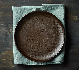 Image showing Dark empty plate on wood table