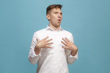 Image showing The young attractive man looking suprised isolated on blue