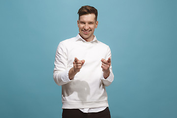 Image showing The happy business man point you and want you, half length closeup portrait on blue background.