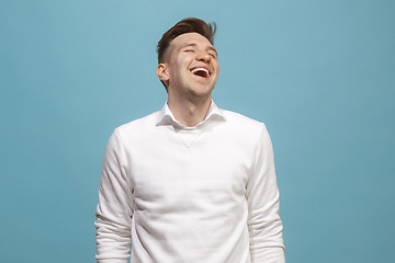 Image showing The happy business man standing and smiling against blue background.