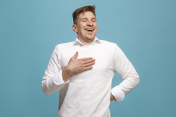 Image showing The happy businessman standing and smiling against blue background.