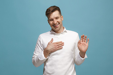 Image showing The happy businessman standing and smiling against blue background.