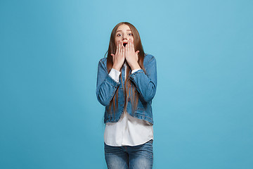 Image showing Beautiful teen girl looking suprised isolated on blue