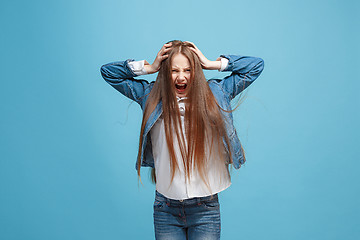 Image showing The squint eyed teen girl with weird expression isolated on blue