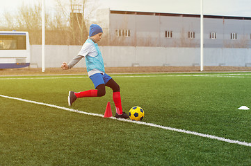 Image showing Boy kicking soccer ball