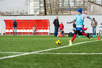 Image showing Boy kicking soccer ball