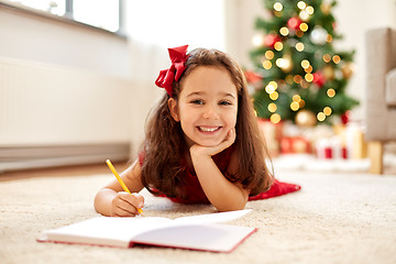 Image showing little girl writing christmas wish list at home