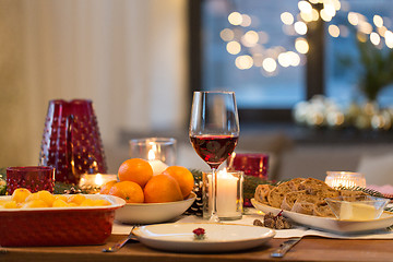 Image showing glass of red wine and food on christmas table