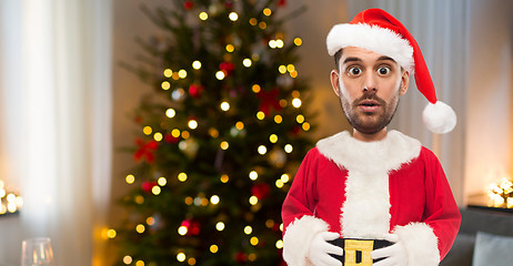 Image showing surprised man in santa clothes over christmas tree
