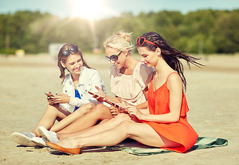 Image showing group of happy women with smartphones on beach