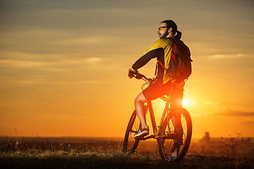 Image showing Man in helmet and glasses stay on the bicycle