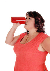 Image showing Plus-sized woman drinking from red mug