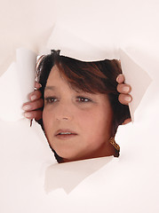 Image showing Woman peeking though paper hole