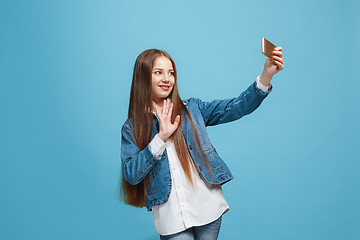 Image showing The happy teen girl standing and smiling against pink background.