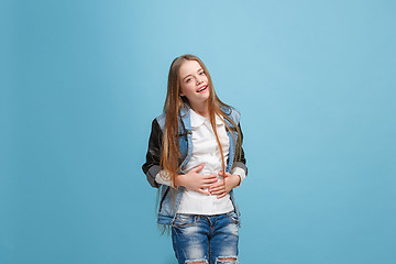 Image showing The happy teen girl standing and smiling against pink background.