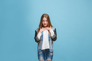 Image showing The happy teen girl standing and smiling against pink background.