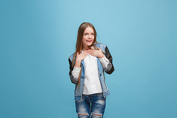 Image showing The happy teen girl standing and smiling against pink background.